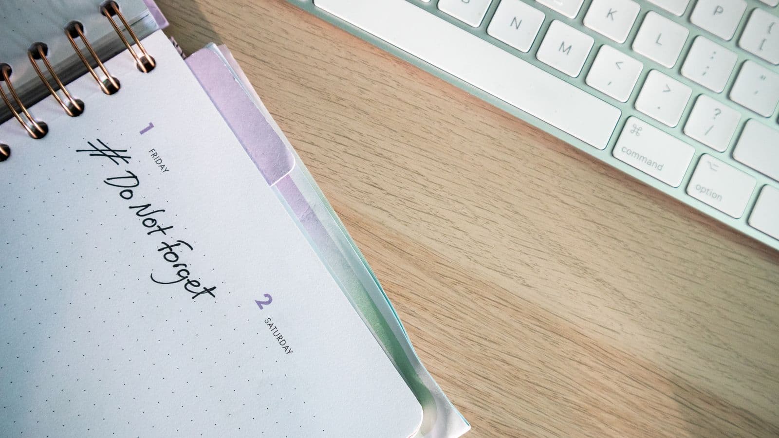 Agenda ouvert et clavier sur un bureau en bois — rythme de publication d'un blog SEO